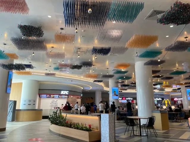 מתחם מזון עם תקרה מעוטרת בריבועים צבעוניים תלויים ושולחנות סועדים