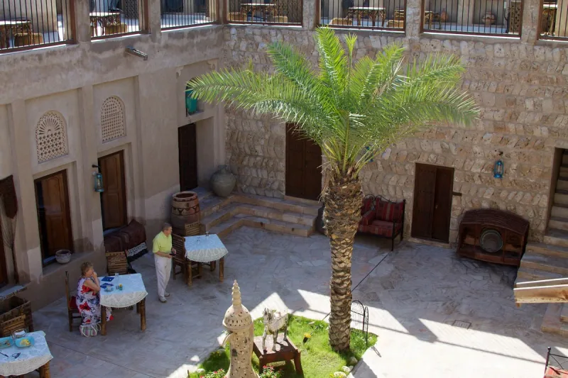 חצר מסעדה מסורתית עם דקל וקירות אבן