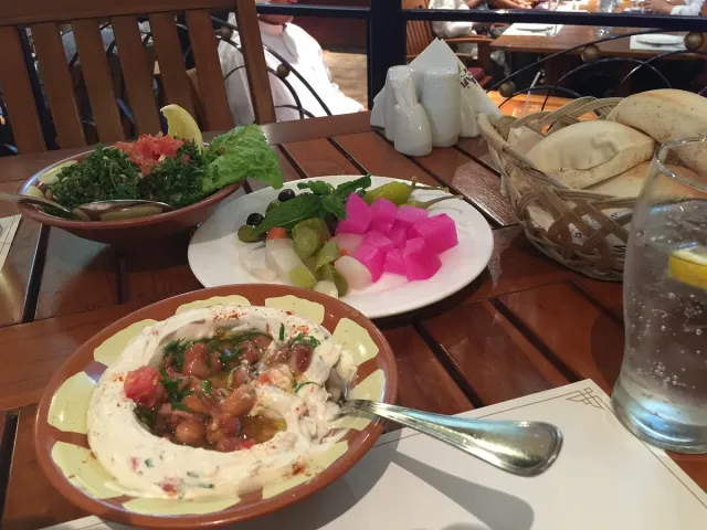 מנות מזה לבנוניות על שולחן עץ לצד סלט ולחם